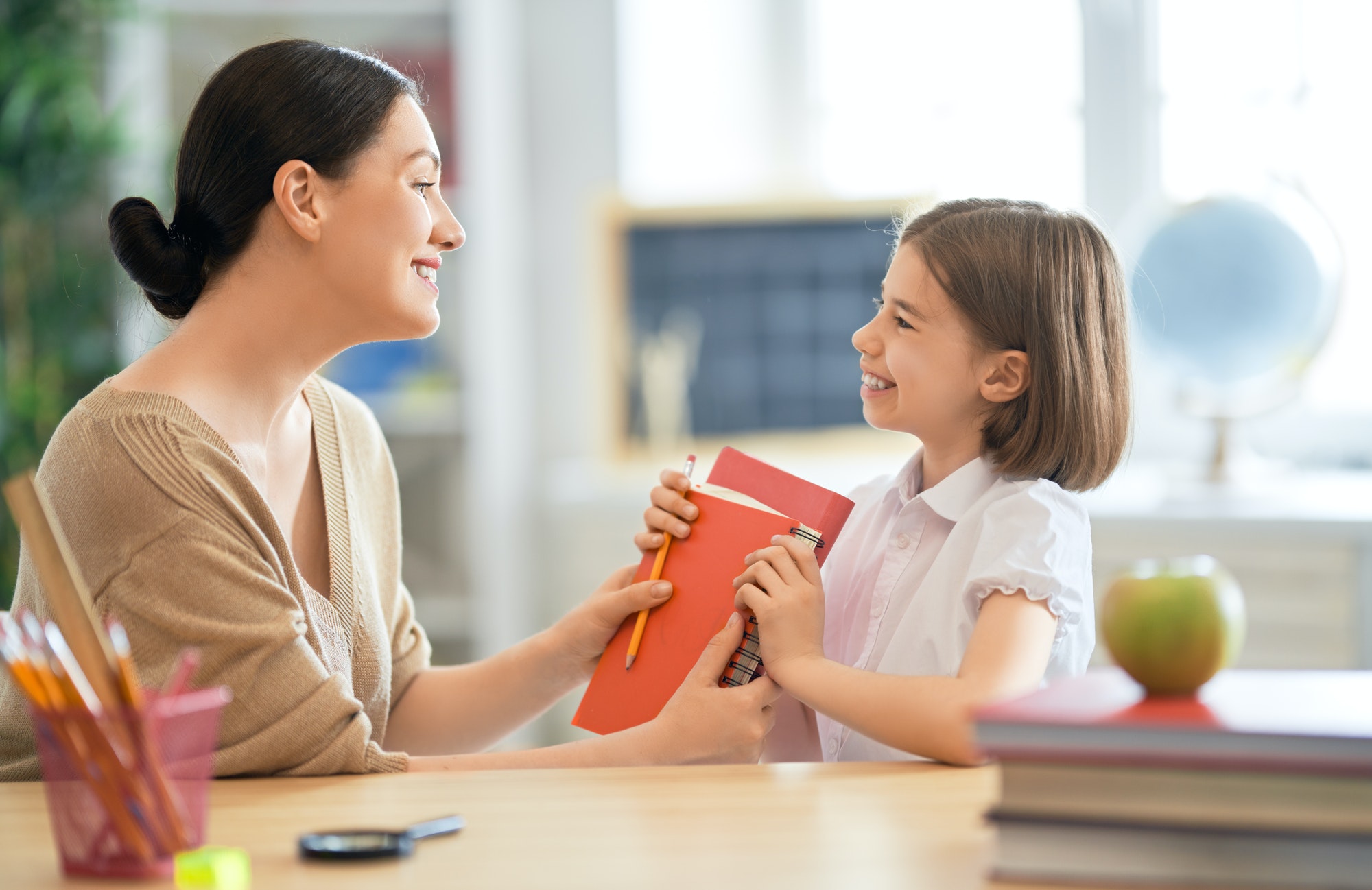 Girl with teacher in classroom.